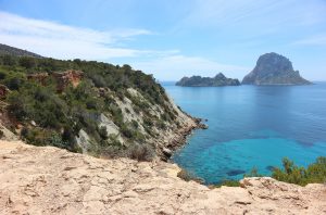 Cala Es Vedra en Ibiza con agua transparente e islas del mar Mediterráneo al fondo